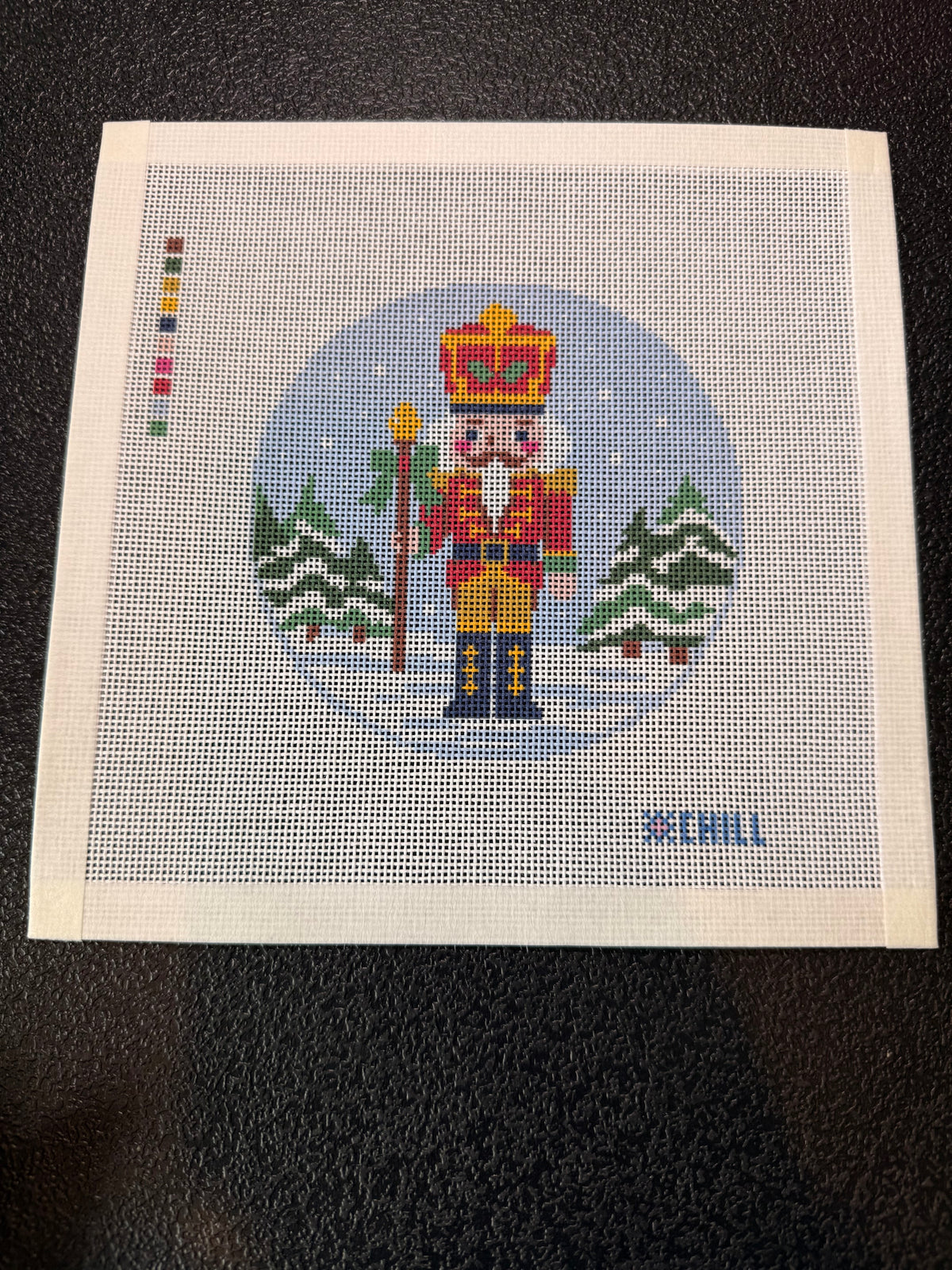 Christmas nutcracker needlepoint canvas held in hand to show size