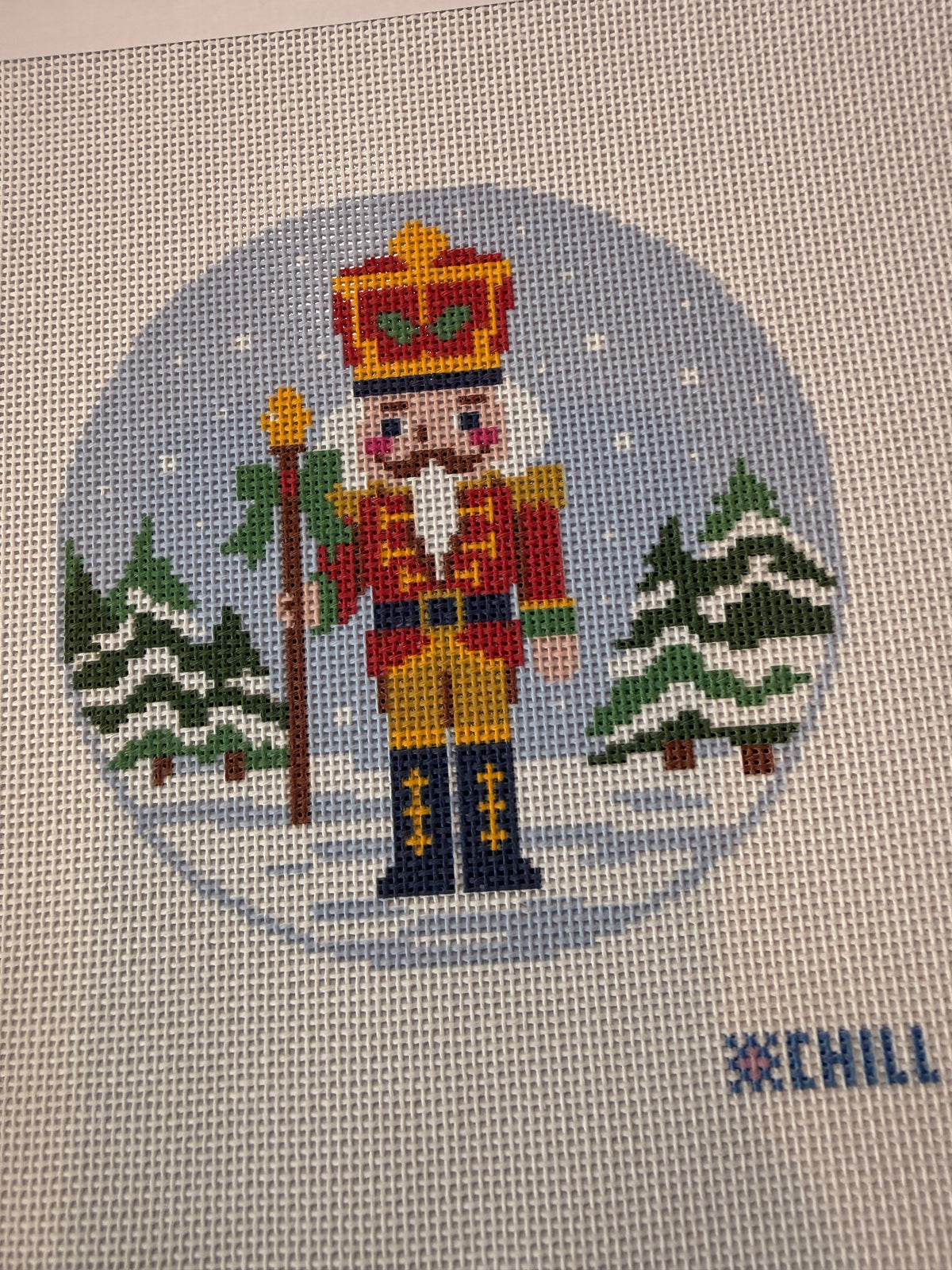Nutcracker needlepoint canvas with snowy evergreens and color key along the side